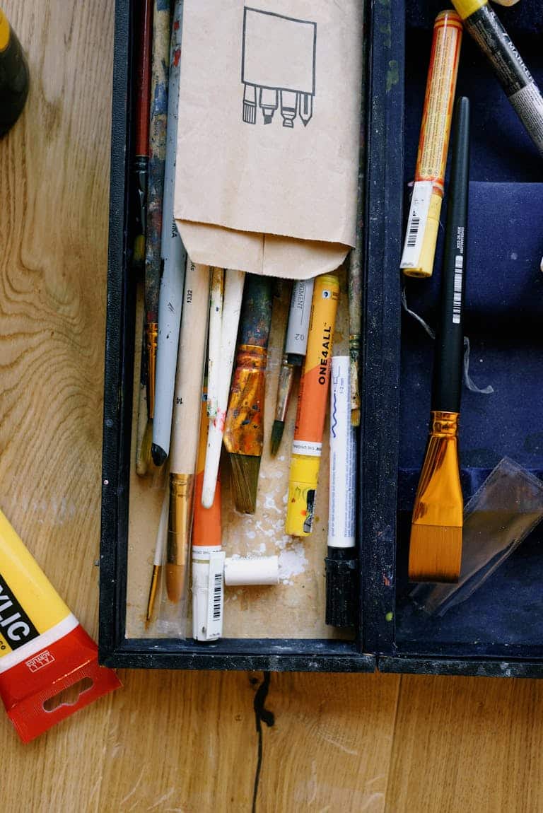 Artist case with assorted paint brushes on wood